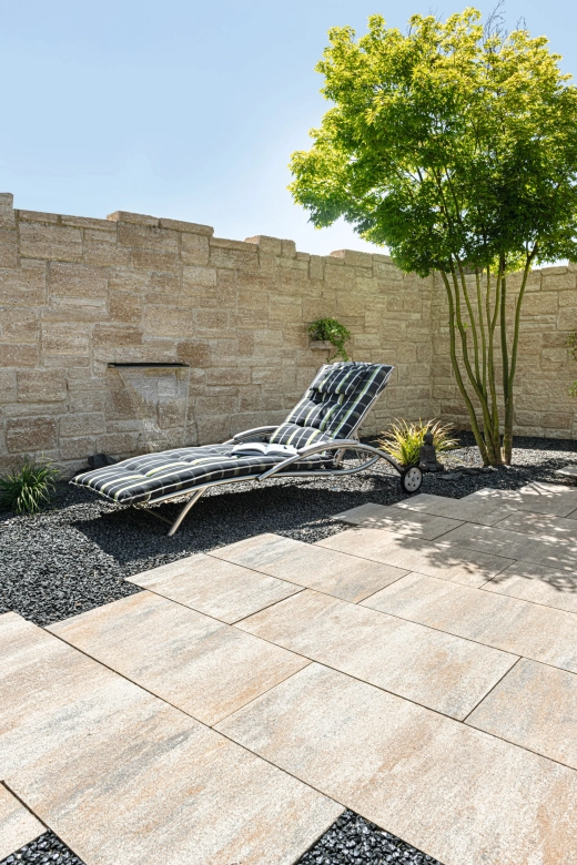 Terrasse mit Terrassenplatten und einem Liegestuhl