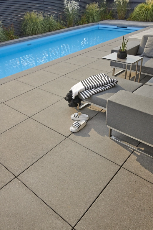 Terrasse mit großen Terrassenplatten aus Beton  und länglichen Pool 