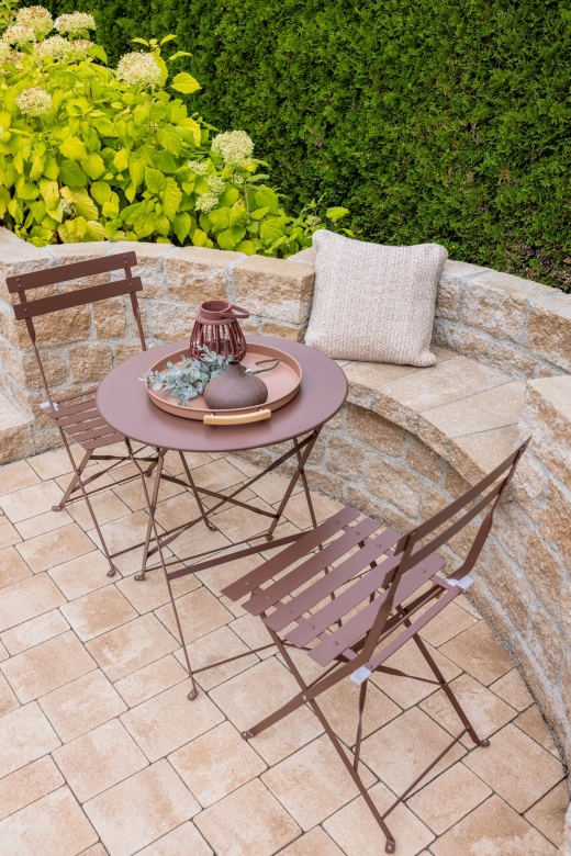 Moderner Gartenraum mit Sitzplatz, Mauer als Bank und üppiger Bepflanzung