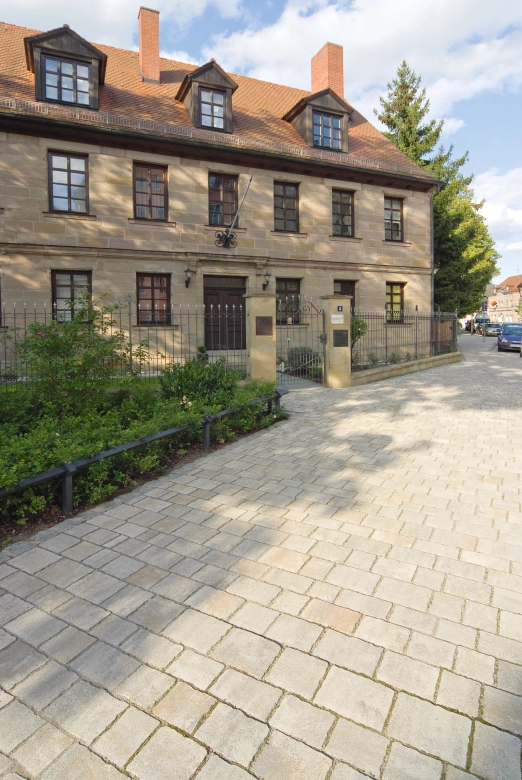 Barocke Villa aus Sandstein eingezäunt mit einem geschmiedetem Eisenzaun
 und SÄulen aus Sandstein. Der Zugang zu dem Haus wurde mit Natursteinen
 in Muschel-Kalk gepflastert.
