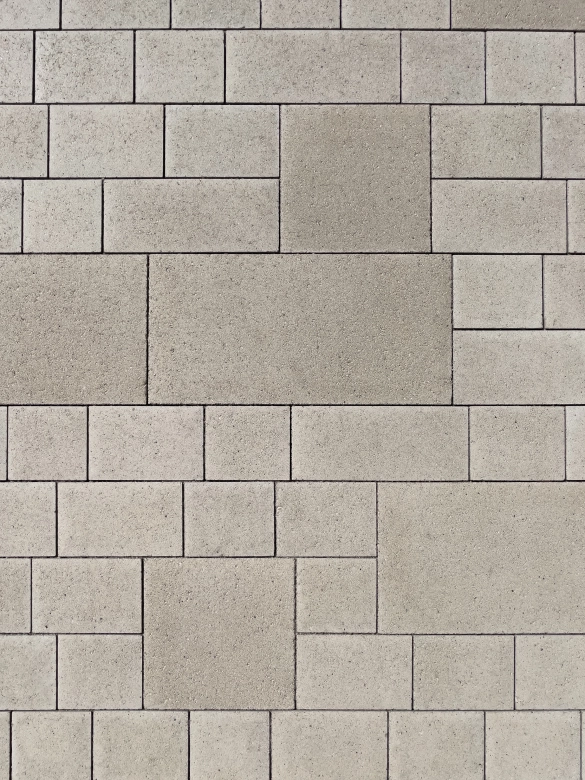 Bird's eye view of a limestone-colored paving with mixed formats of large and small.