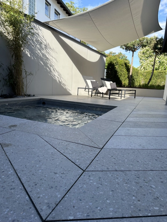 GDM.AWA tile auf derm Boden einer Spa-Terrasse mit Whirlpool - in einer Terrazzo-Variante im Fischgrätverband verlegt.