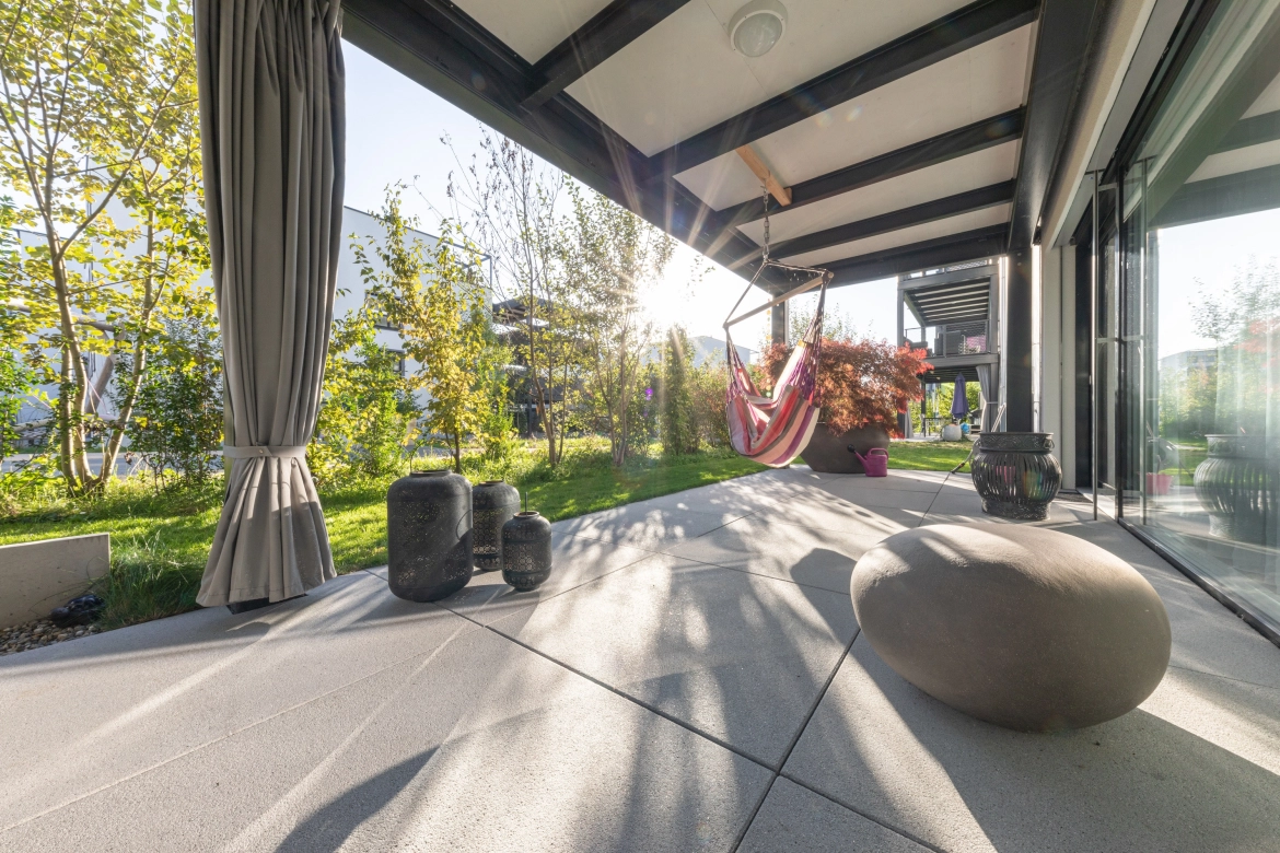 Wohnüberbauung in der Schweiz mit Terrassenplatten bei sonnigem Wetter.