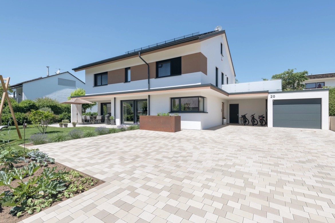 Detached house with wooden elements and natural paving stones in light limestone 