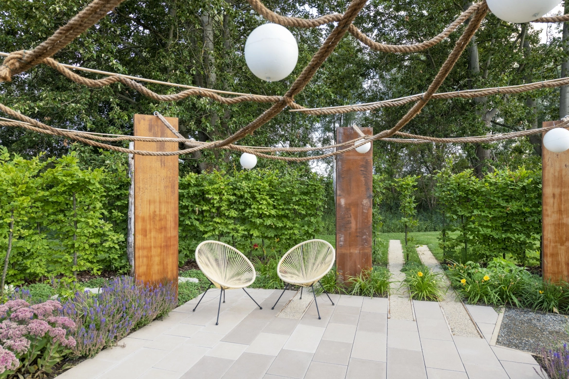 Outdoor terrace with Corten steel-look columns and a limestone-colored paving stone from the State Garden Show in Beelitz.