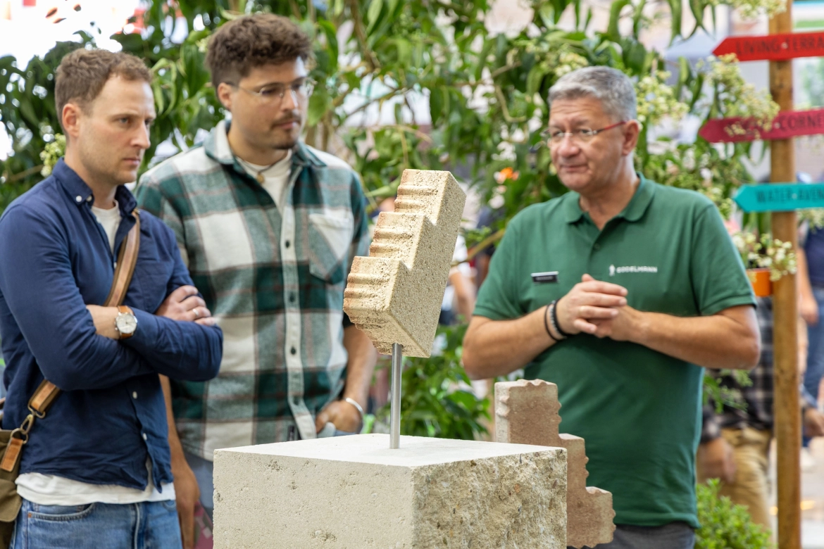 Besucher im Gespräch mit einem Außendienst-Mitarbeiter über den GDM.CASCADE stone als GDM.KLIMASTEIN