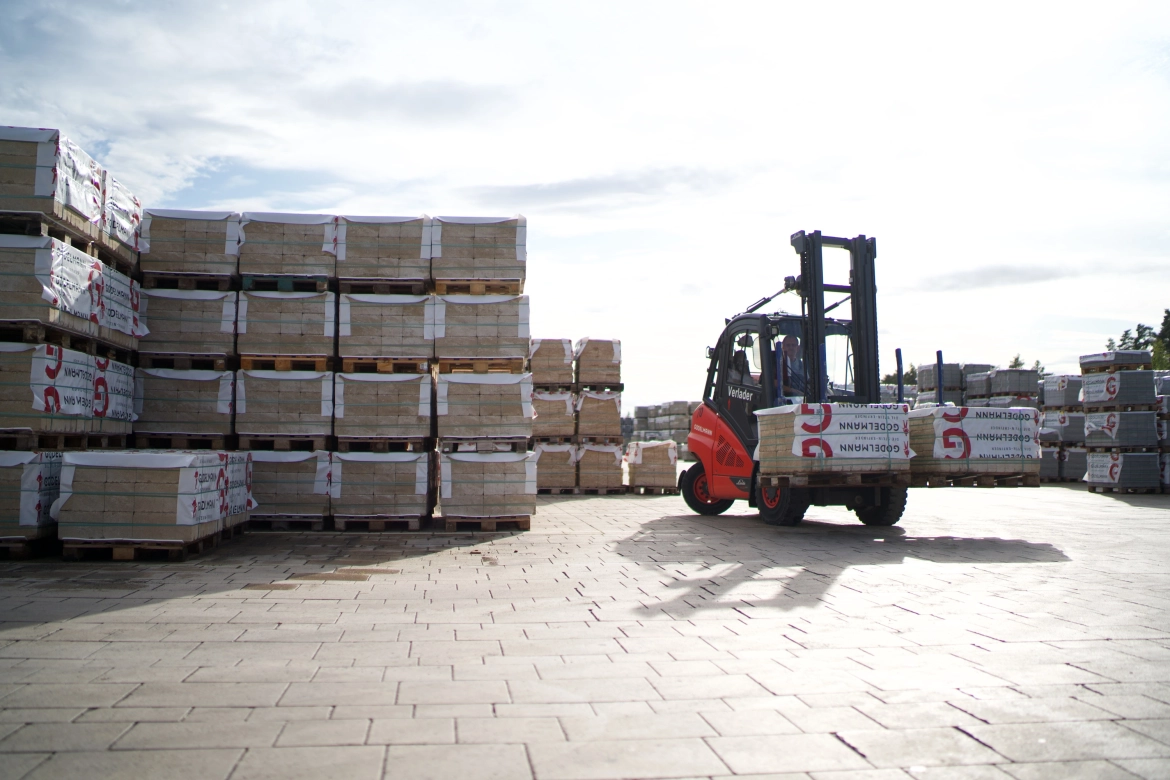 Forklift loaded with two stone packages moves in the warehouse.