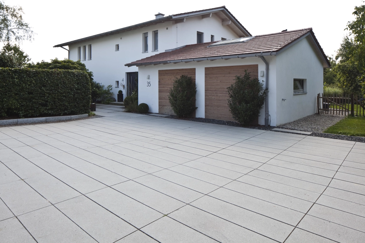 längliche Pflastersteine zu einem modernen Haus mit einer Doppelgarage 