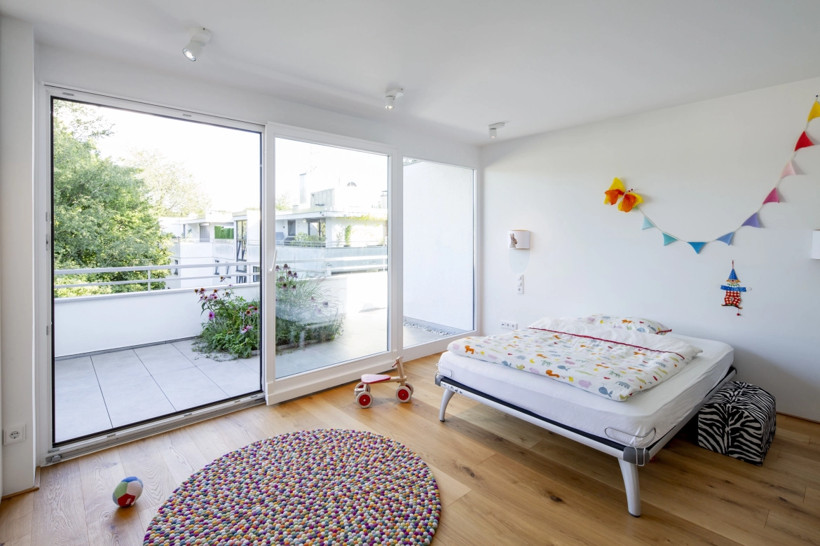 Blick von einem modernen Kinderzimmer auf den Balkon mit Betonfliesen