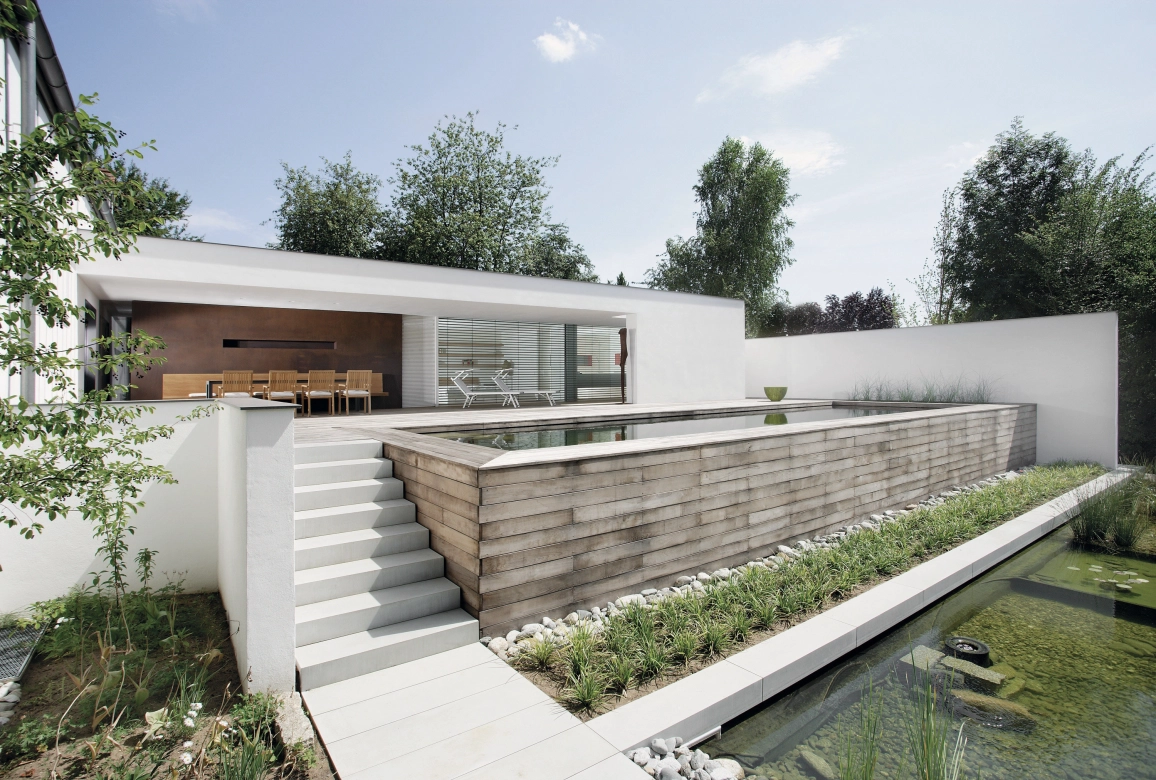 moderner Hausanbau in Bauhaus-Stil mit Wasserbecken und Blockstufen aus Beton 