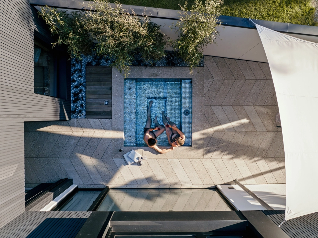 Kleiner Pool, umgeben von Terrassenplatten in Terrazzo-Optik, verlegt im stilvollen Fischgrätenverband