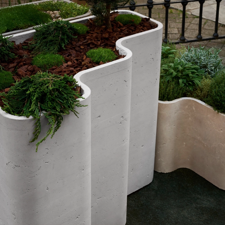 Planter in ausgewöhnlicher Form vom Designer Bodo Sperlein grün bepflanzt