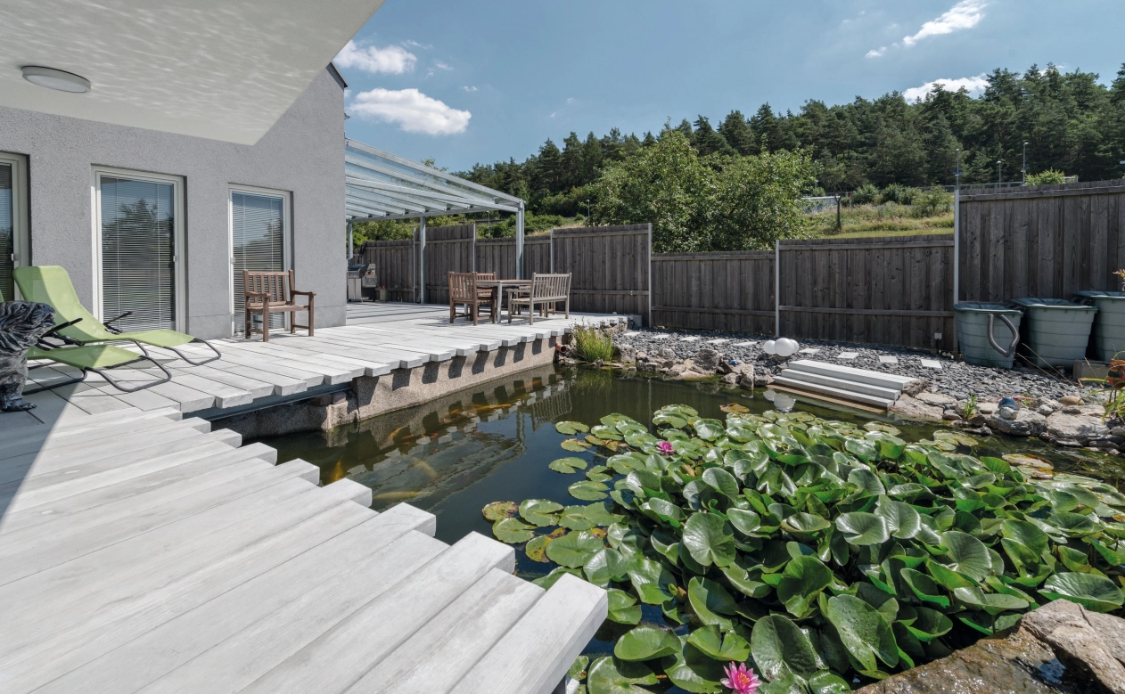 natürlicher Gartenteich, umrandet mit Dielen in Holzoptik aus Beton