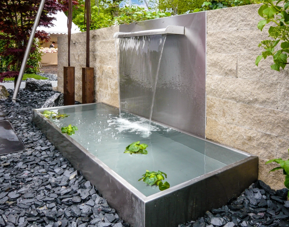 Wasserlauf in einer Betonmauer und Aluminium Becken 