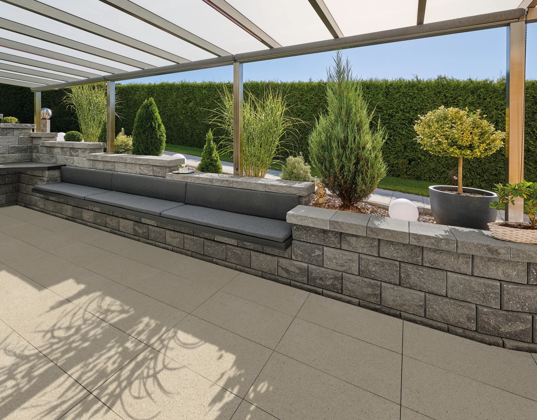 überdachte Terrasse mit Terrassenplatten in der Farbe Kalkstein hell