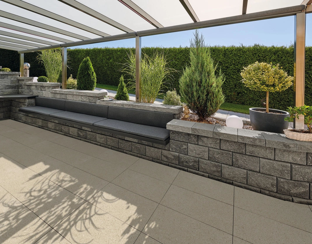 überdachte Terrasse mit Terrassenplatten in der Farbe Kalkstein hell