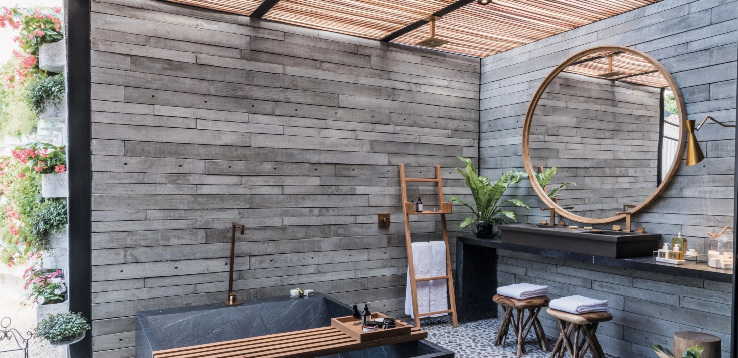  Betonfliesen GDM.APPARENTE tile an der Wand verbaut. Im Vordergrund ein Tisch