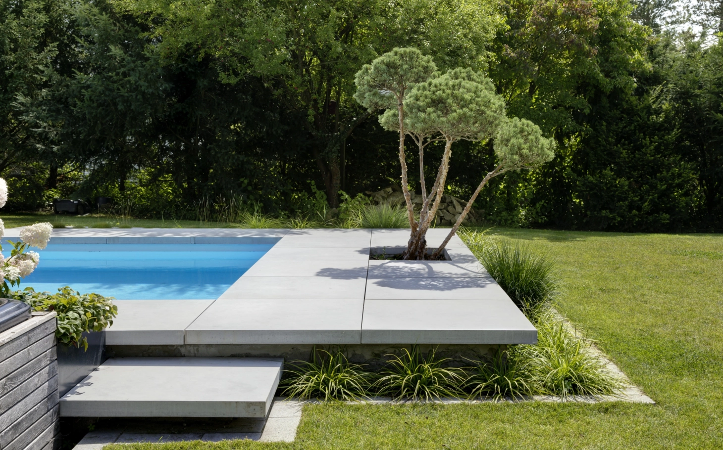 Pool mit großen Terrassenplatten und Schwebestuf