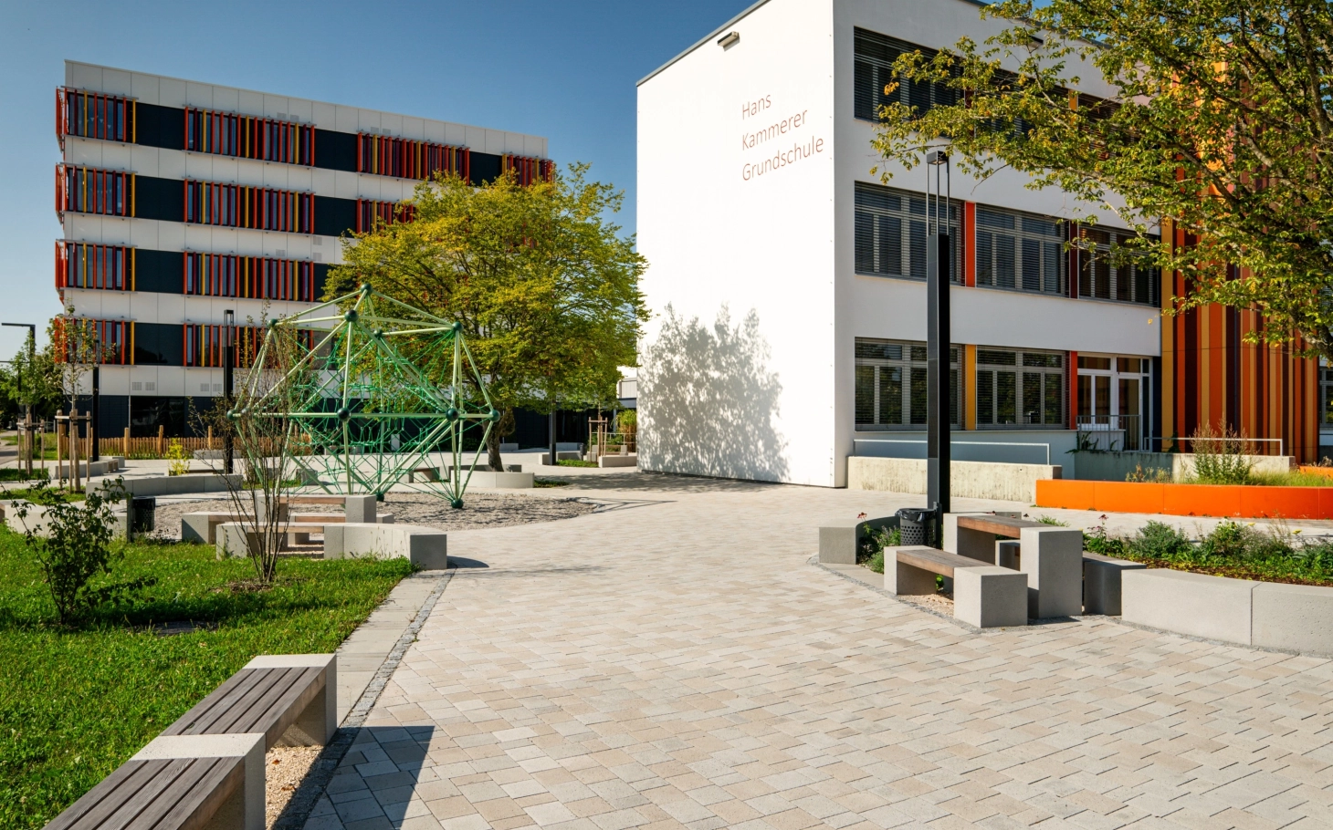 Schulanlage mit Blick auf Pausenhof und zwei Schulgebäude der Hans Kammerer Schule.