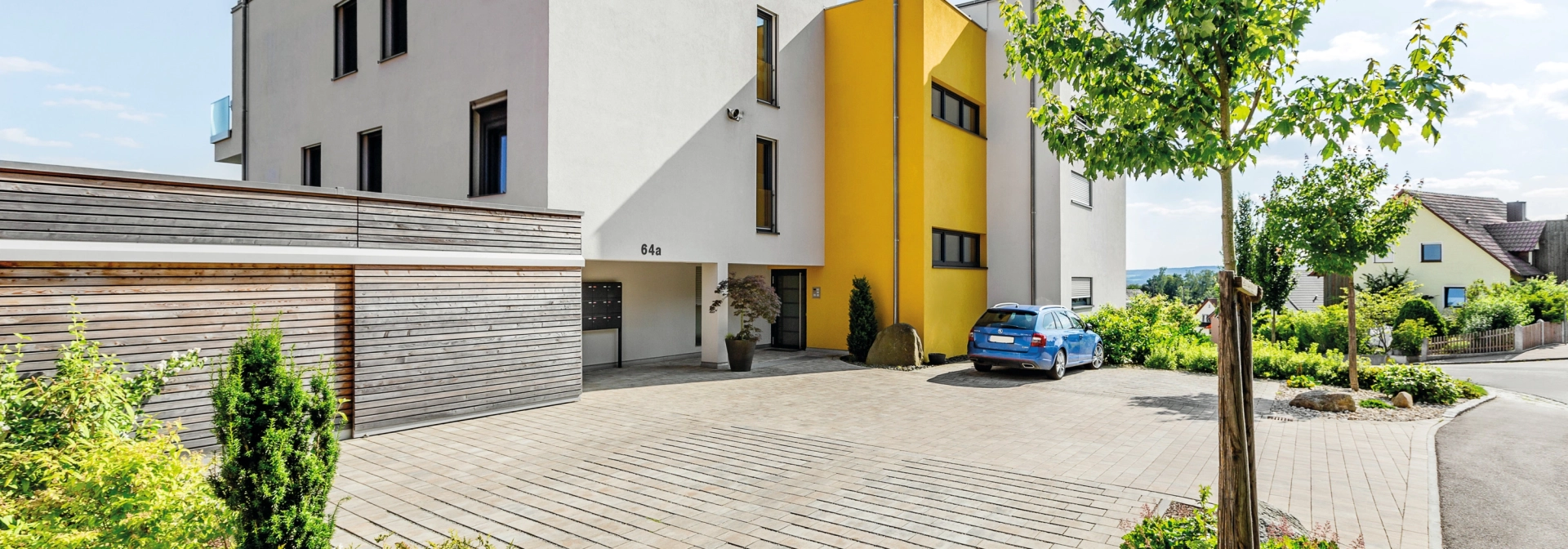 modern apartment building with planted driveway 