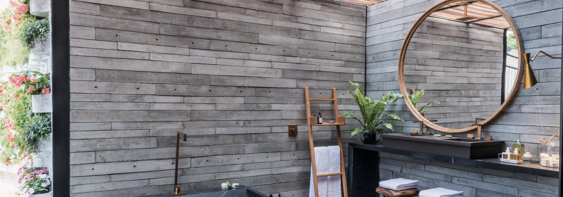  Betonfliesen GDM.APPARENTE tile an der Wand verbaut. Im Vordergrund ein Tisch