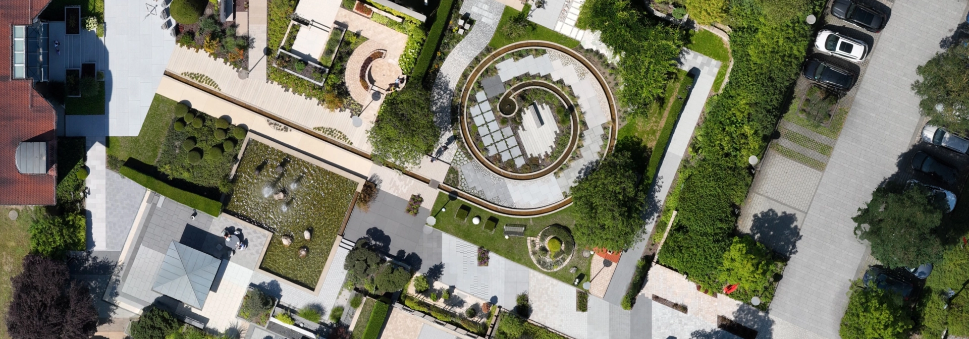 Drohnenaufnahme des Godelmann Ideen-Garten in Fensterbach bei Högling. Darauf sind viele Pflaster- und Plattenwege durch begrünte Bereiche zu erkennen.