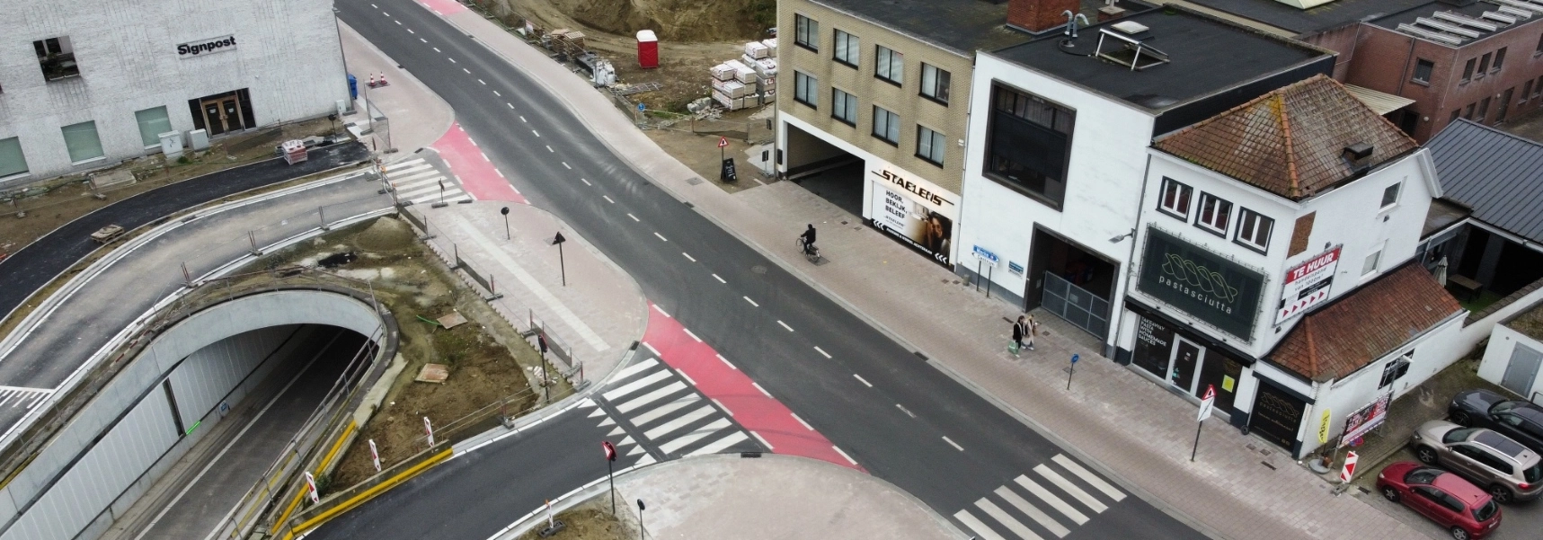 Blick auf eine noch laufende Baustelle neben einer asphaltierten Farbahn in einer Stadt. Die Gehwege wurden mit zeroC Pflastersteinen befestigt.