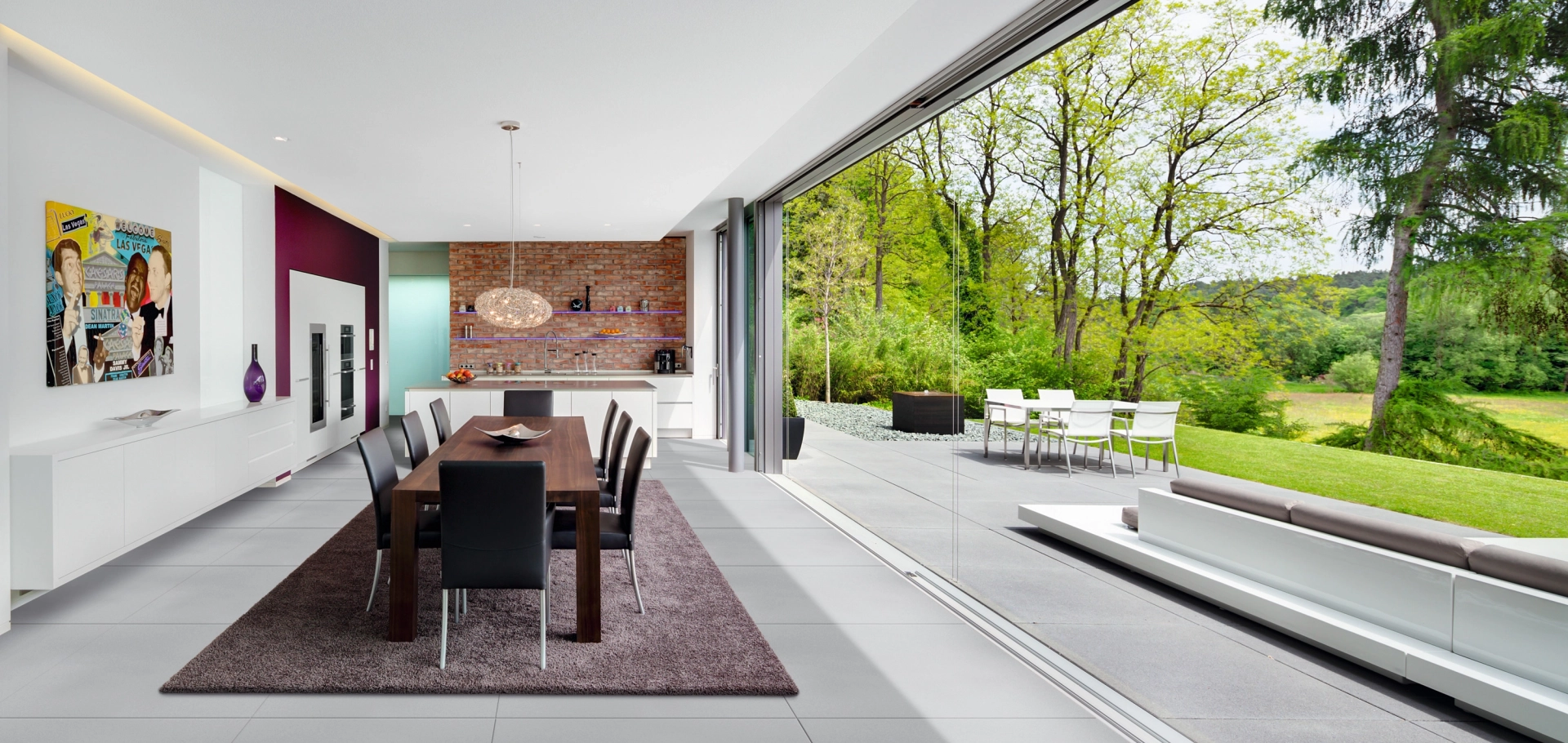 Der Bodenbelag aus großformatigen Betonfliesen verbindet den Wohnraum nahtlosem mit der Terrasse. Die Fliesen haben das selbe Format und die selbe Optik.