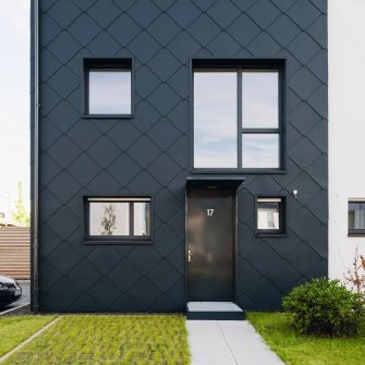schwarzes Reihenhaus  mit schmalen Eingangsbereich
