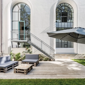 Loft mit industriellem Eingang und Terrasse mit Betonplatten in Holzoptik 