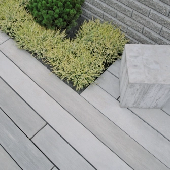 Betondielen in Holzoptik und einem Betonwürfel als Sitzelement