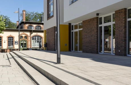 Rathaus am Marktplatz Beelitz-Heilstätten mit vorgelagerter Stufenanlage aus Godelmann GDM.NUEVA Step in der Farbe Sandstein-Uni und angrenzender Platzgestaltung.