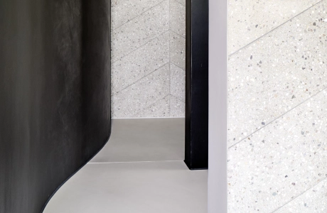 Minimalistisches Badezimmer in Schwarz, kombiniert mit sandgrauen Terrazzo-Fliesen in Fischgrät-Optik für eine elegante und moderne Atmosphäre.