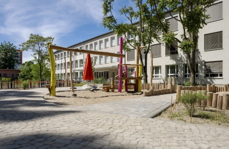 Außenbereich der Kita Wolkenschaf in Berlin mit naturnahen Spielgeräten und versickerungsfähigem GDM.BOLERO.