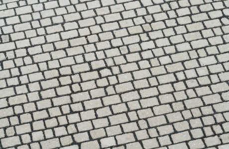 Draufsicht einer Pflasterfläche mit dunklen Fugen. Verbaut ist hier eine Alternative zum Naturstein: der GDM.ACENTRO stone.