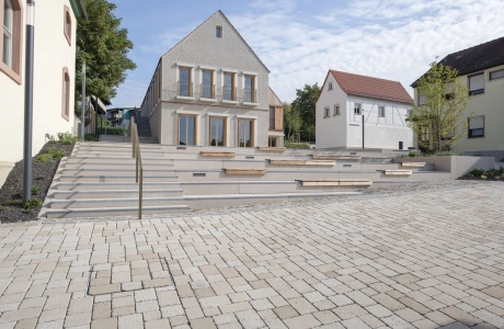 Breite Stufen führen zu einem modernen Haus mit ökologisch gepflastertem Vorplatz.