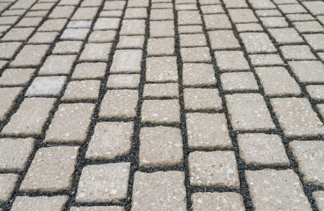 Draufsicht einer Pflasterfläche mit dunklen Fugen. Verbaut ist hier eine Alternative zum Naturstein: der GDM.ACENTRO stone.