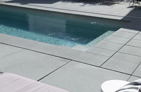 Graue GDM.NUEVA light Platten um einen Pool herum verlegt. 