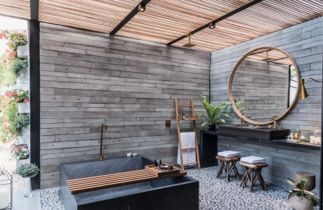  Betonfliesen GDM.APPARENTE tile an der Wand verbaut. Im Vordergrund ein Tisch