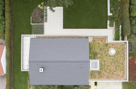 Luftaufnahme eines modernen, cleanen Einfamilienhauses mit großem Garten.