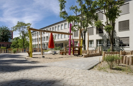 Außenbereich der Kita Wolkenschaf in Berlin mit naturnahen Spielgeräten und versickerungsfähigem GDM.BOLERO.