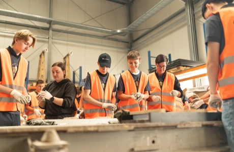 Beton-Workshop mit jungen Personen, die Spaß beim befüllen der Formen mit Beton haben.