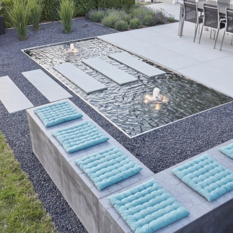Moderne Terrasse mit integrierten Wasserbecken und Sitzblöcken aus Beton