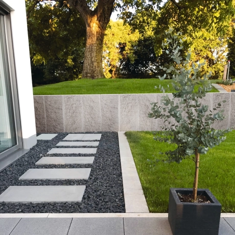 GDM.MAXI L-wall zur Hangabsicherung in einem Garten mit Terrasse.