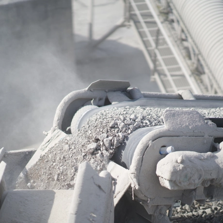 Recycled sand from crushed paving stones being transported on a conveyor belt.