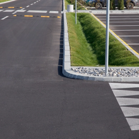 ein schwarz geteerter Parkplatz. Die Fläche ist versiegelt.