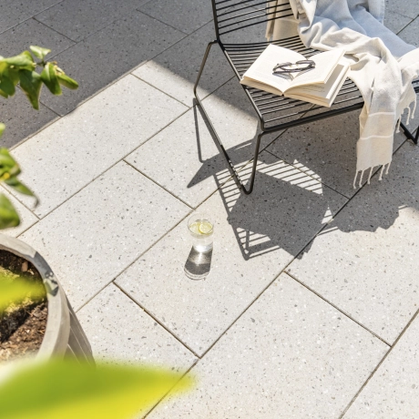 Rechteckige Terrassenplatten mit geschliffener Oberfläche in Terrazzo Beige sind im 2/3 Verband verlegt und sind pflegeleicht. 