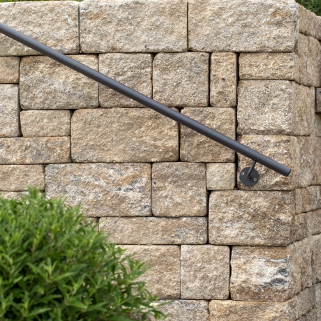 Muschel-Kalk-farbene Mauer mit Geländer.