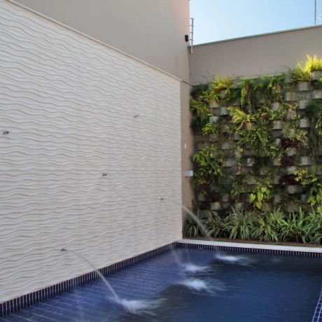 versteckter Pool mit begrünter Wand und Architekturbeton Wänden mit Wasserfontänen 
