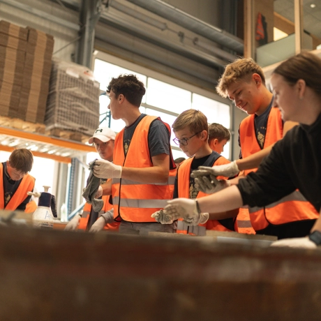 Beton-Workshop mit jungen Leuten, die Spaß beim befüllen der Formen mit Beton haben.